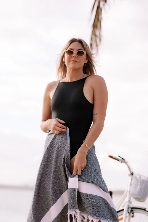 girl at the beach with black Turkish towel 