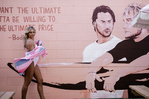 Girl walking past sign holding Turkish towel 