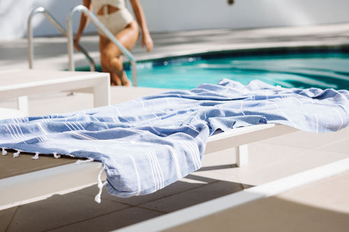 Girl getting out of pool and Turkish towel on sunbed